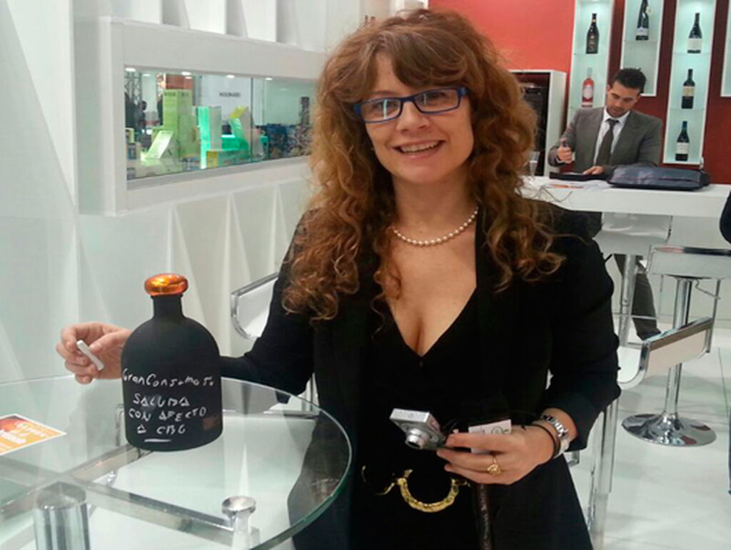 Eduina Batalla, de comercial CBG, posa con un nuevo lambrusco en botella de pizarra autografiada por GranConsumo.tv