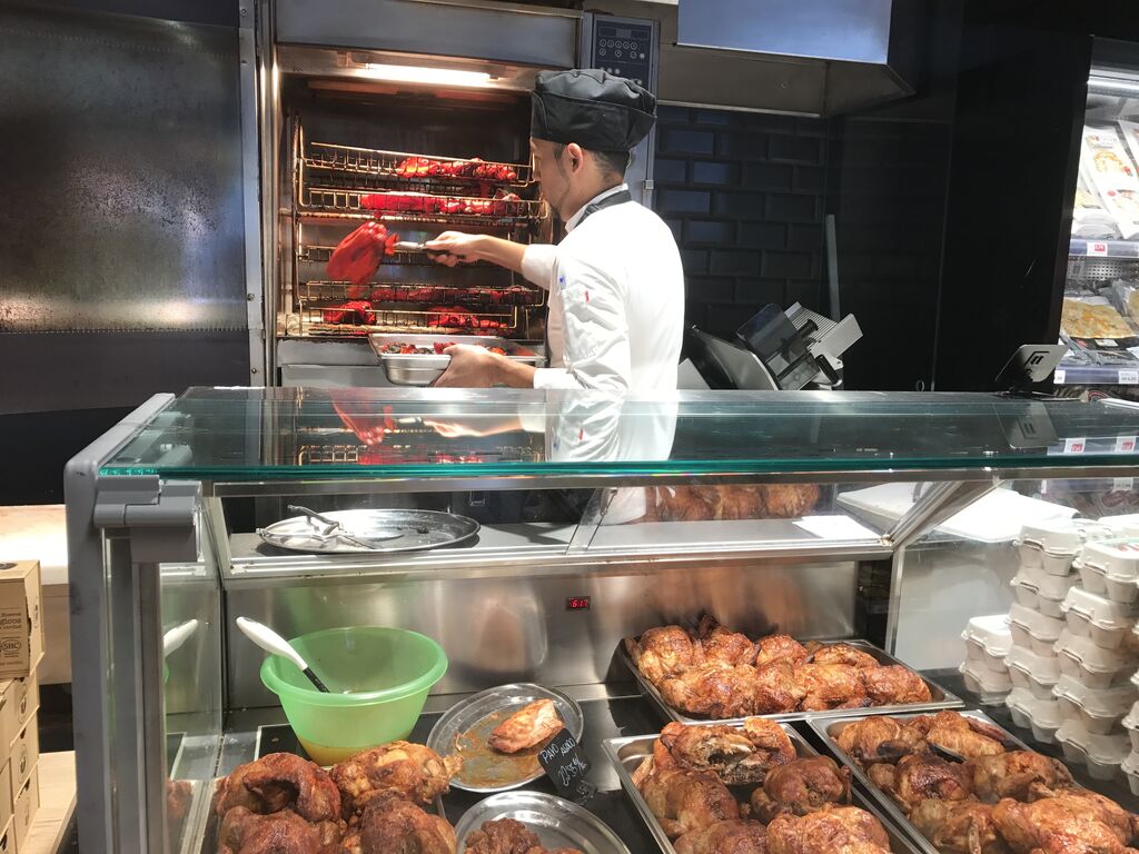 Un empleado de Sánchez Romero prepara comida para llevar