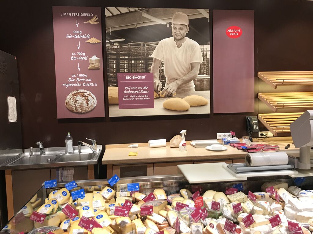Gran variedad de quesos, al lado de una sección de panadería donde enseñan a preparar pan ecológico.