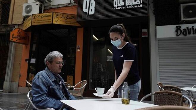 Una camarera atiende a un señor en la terraza de un bar en Córdoba en el primer día de la fase 1 en esta provincia. Efeagro/Rafa Alcaide.