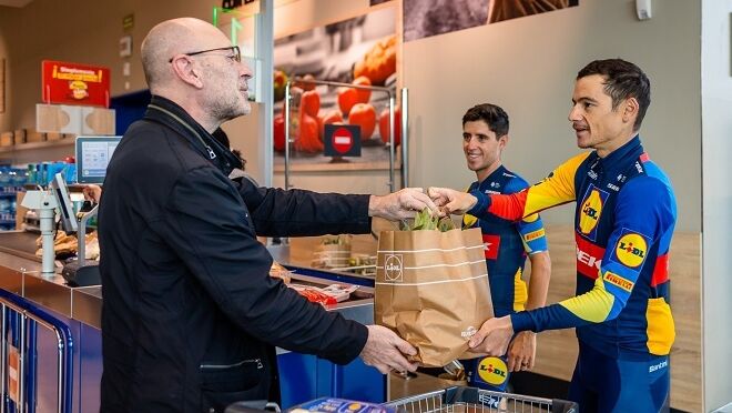 El equipo ciclista Lidl-Trek reparte fruta a los clientes en un súper de Santander